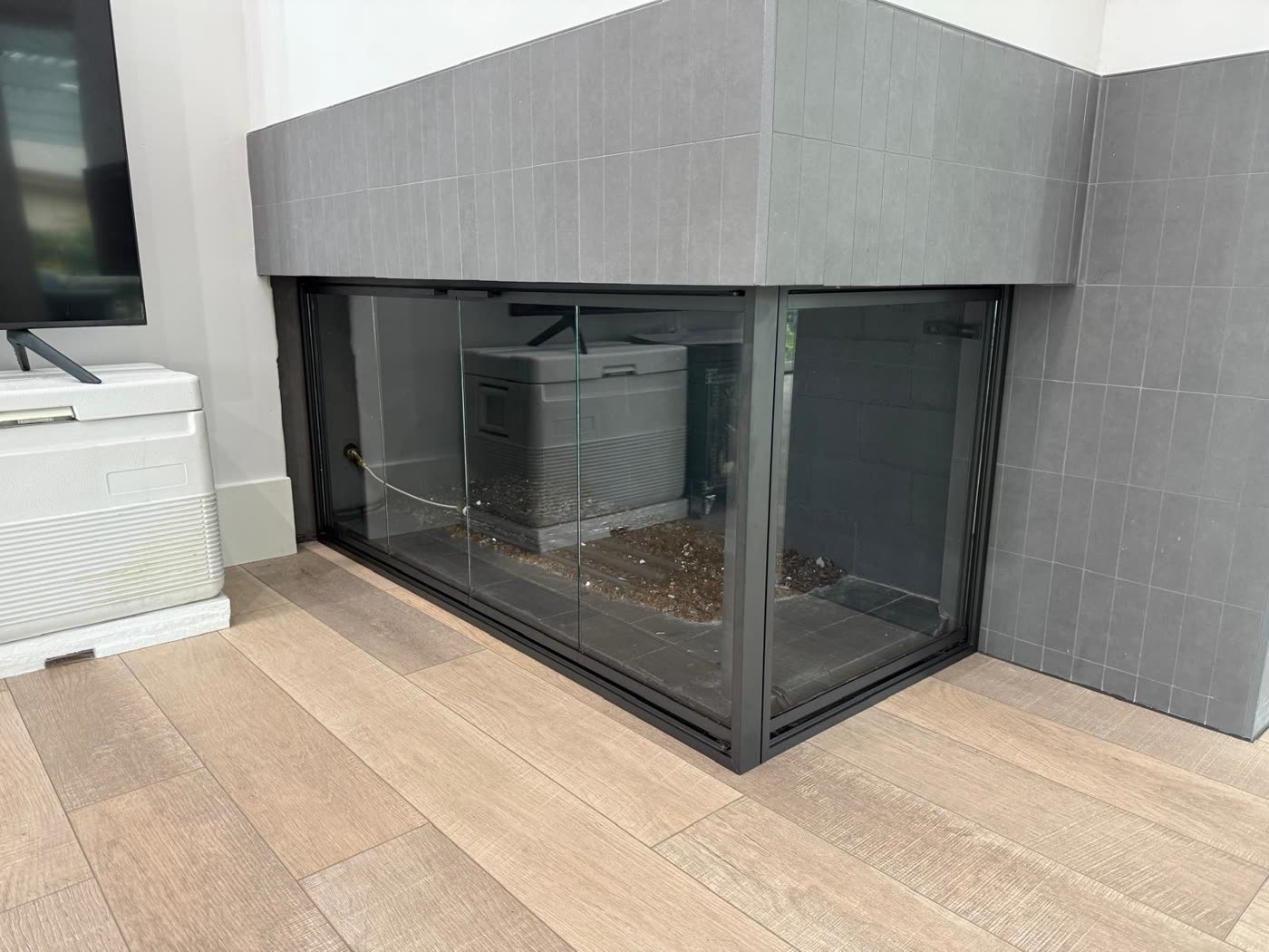 The same corner fireplace with custom L-shape glass doors installed